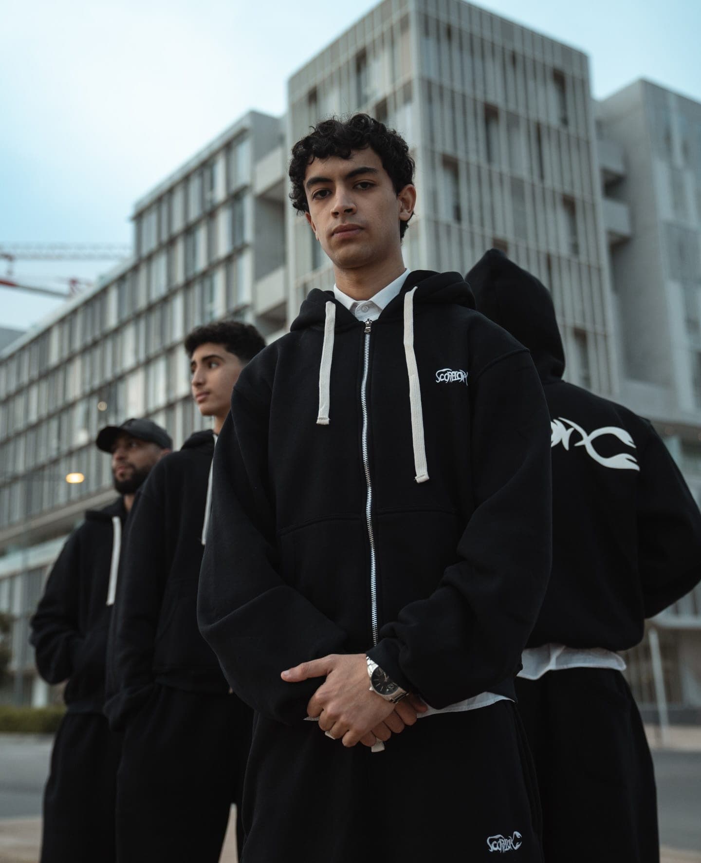 The crew in tracksuits in front of modern apartment blocks