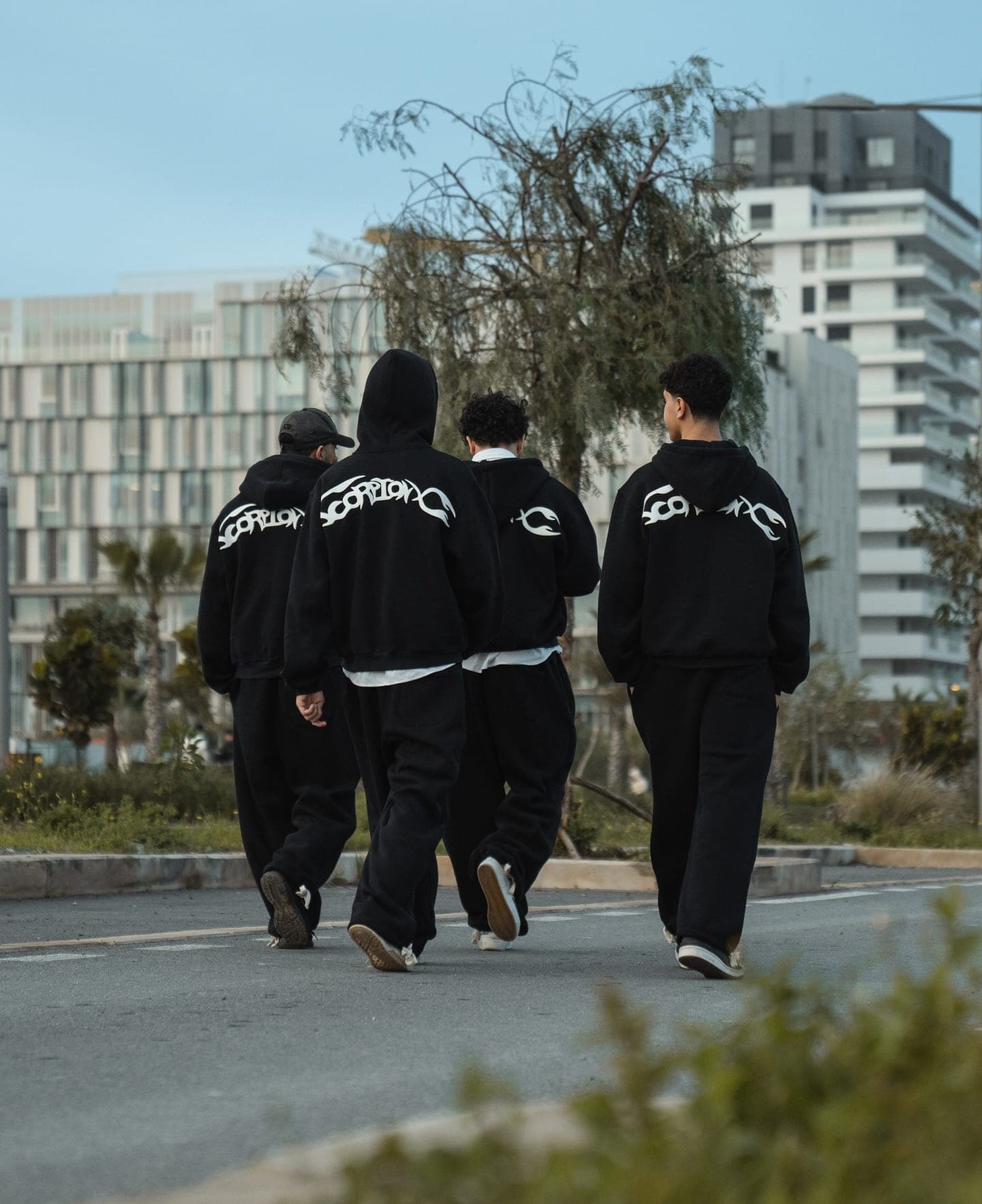 Four crew members walking away with ScorpionX prints across their backs
