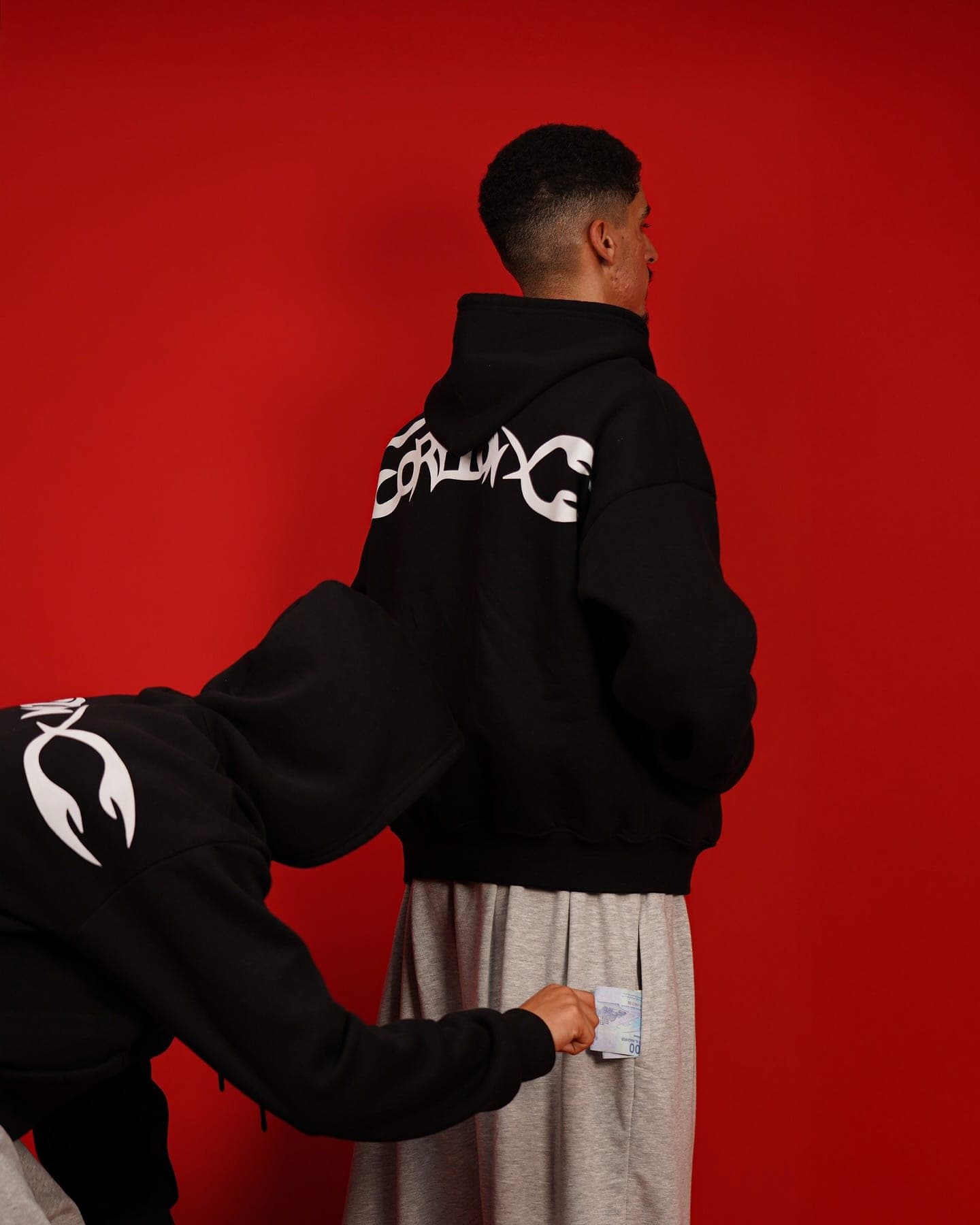 Closer on the red backdrop: the back print and the Toji Sweatpants