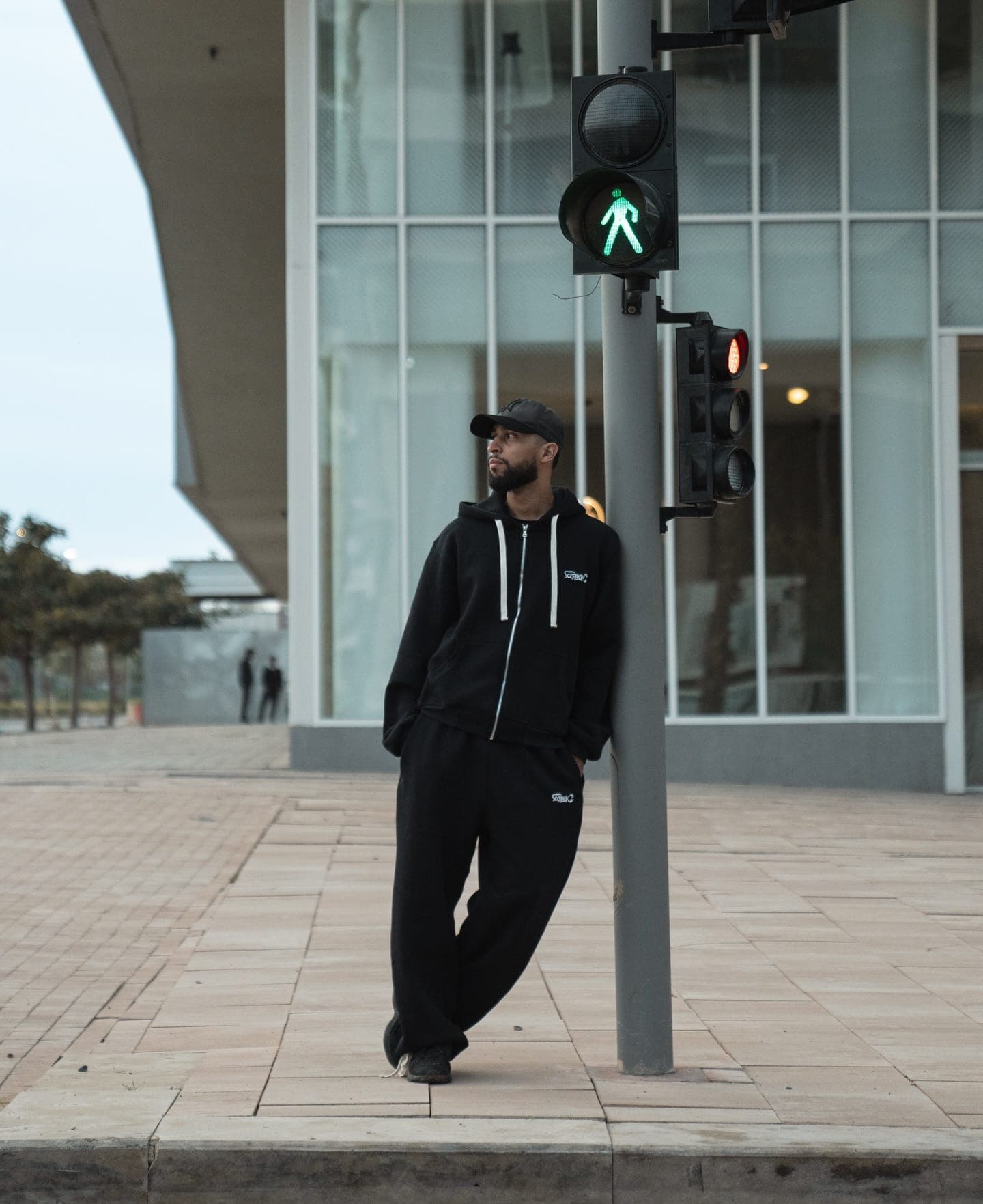 A crew member in the tracksuit leaning on a traffic light
